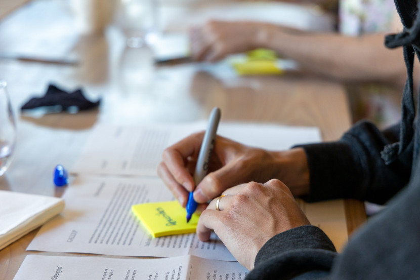 Person writing on a sticky note