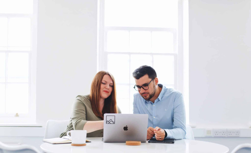 Two people looking at a laptop screen