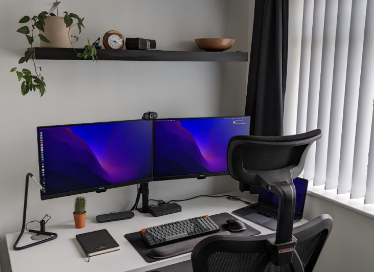 a desk with 2 monitors and a keyboard on it