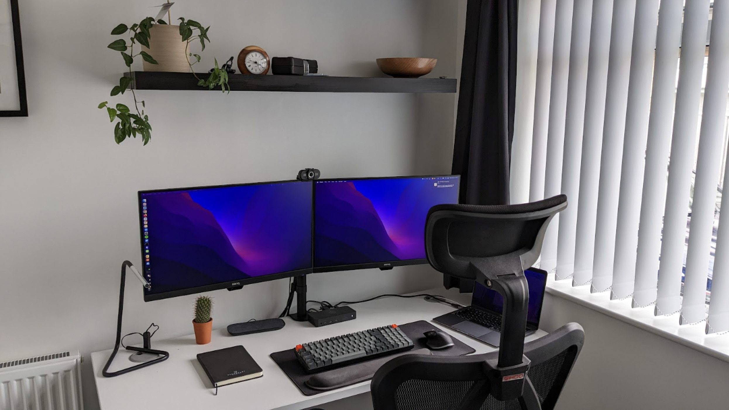 a desk with 2 monitors and a keyboard on it