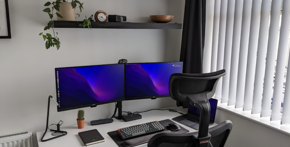 a desk with 2 monitors and a keyboard on it
