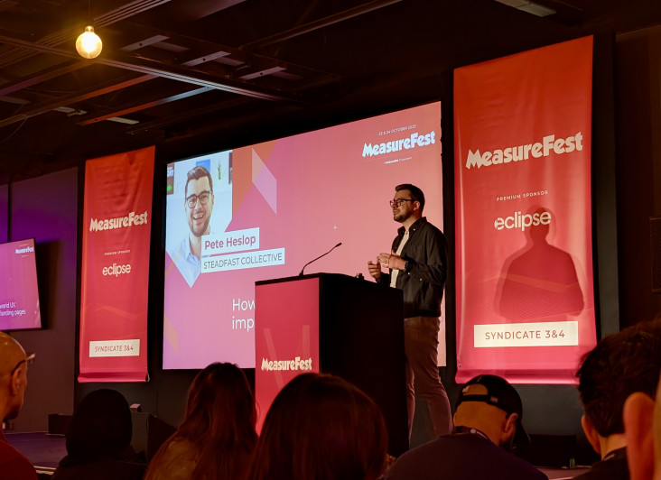 A speaker presents at MeasureFest, with a slide showing 