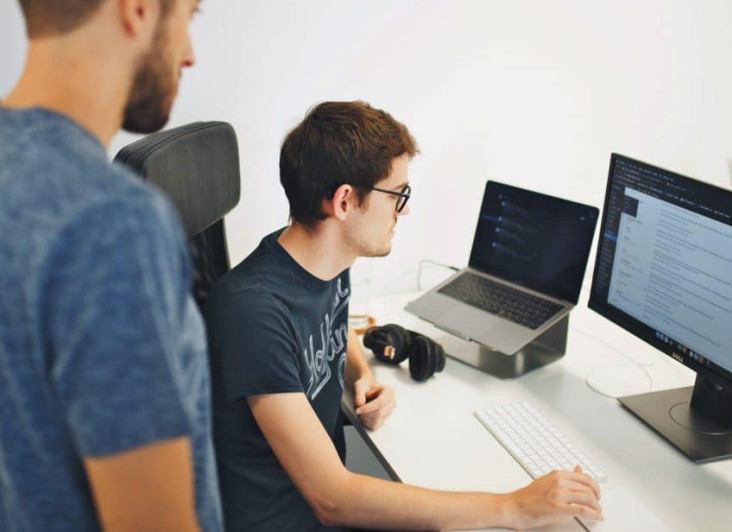 Two people looking at a PC screen