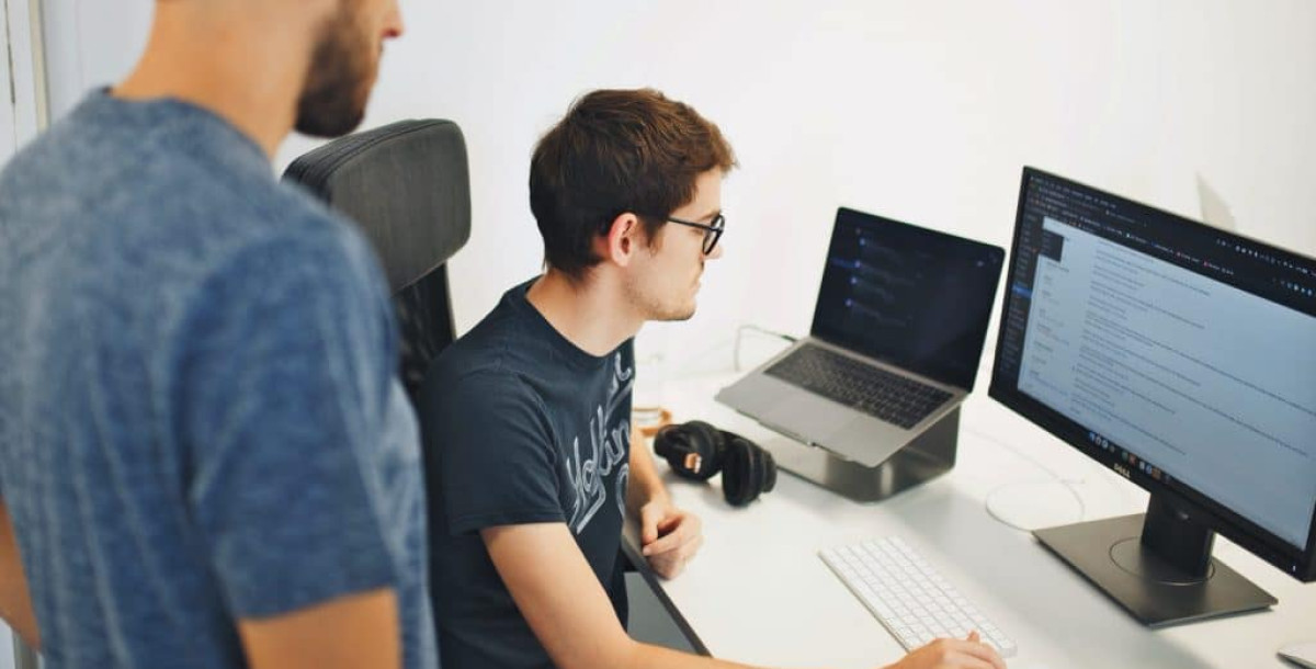 Two people looking at a PC screen