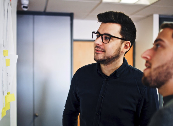 Two people looking at a board